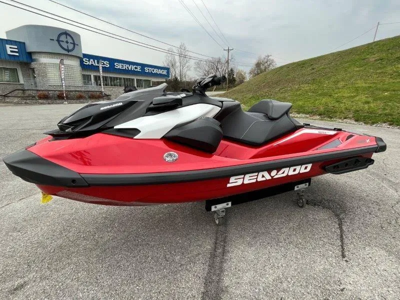 Slide: The Image of 2024 Sea-Doo RXP-X 325 Sound jet ski in red, parked outdoors near sales service building. - 12