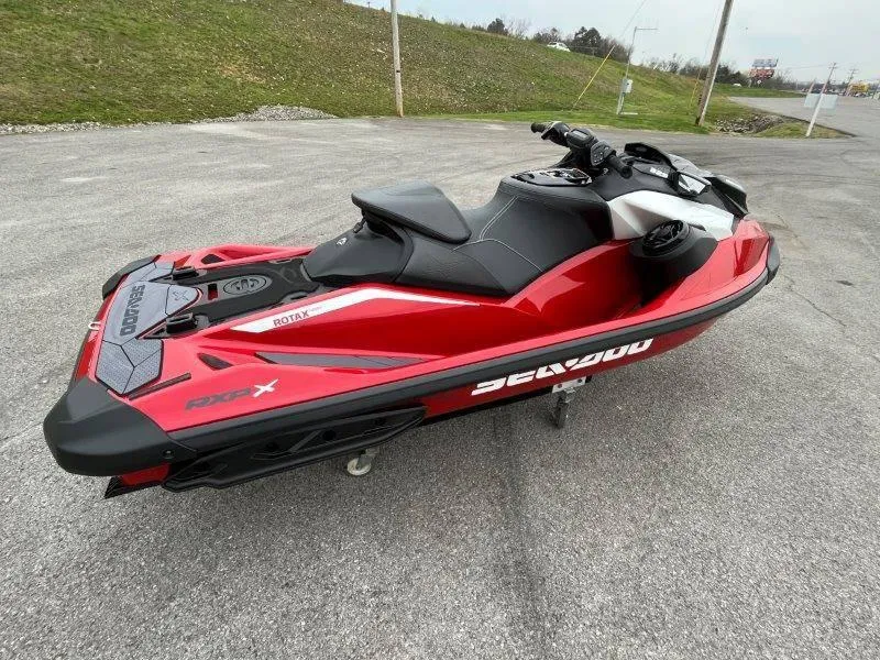 Slide: The Image of 2024 Sea-Doo RXP-X 325 Sound jet ski in vibrant red on pavement. - 15