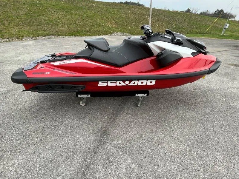 Slide: The Image of 2024 Sea-Doo RXP-X 325 Sound jet ski in vibrant red on pavement. - 2