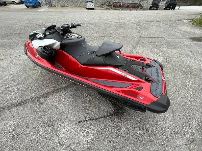 Slide: The Image of 2024 Sea-Doo RXP-X 325 Sound jet ski in vibrant red, parked on pavement. - 28