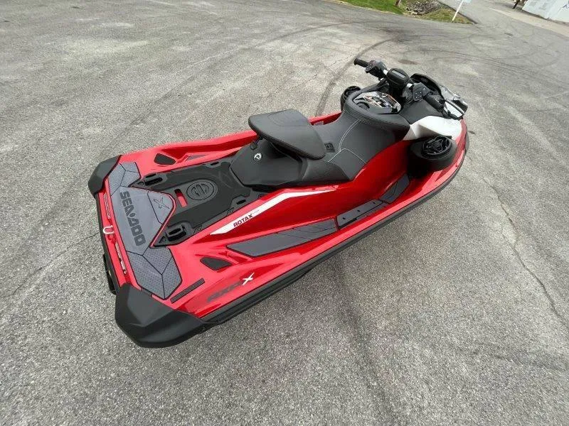 Slide: The Image of 2024 Sea-Doo RXP-X 325 Sound jet ski in vibrant red, parked on pavement. - 29