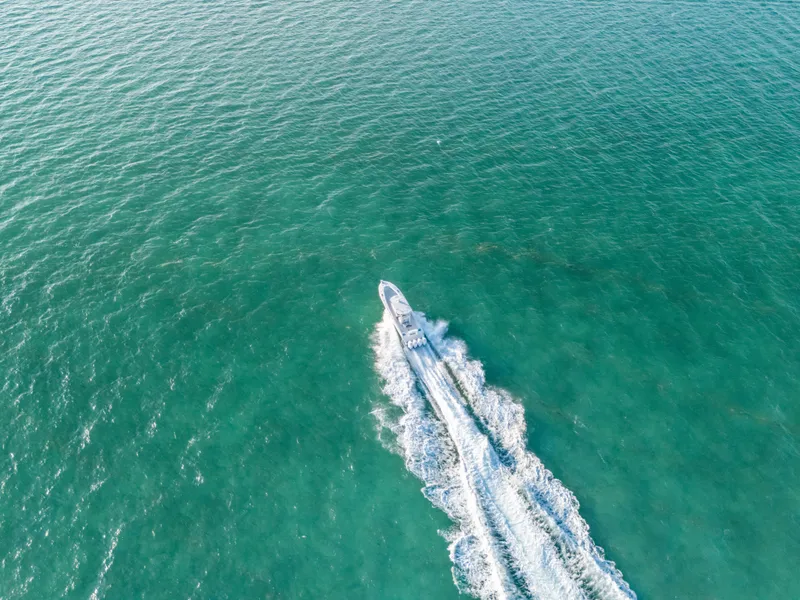 Slide: The Image of Aerial view of 2023 Front Runner 39 Center Console boat cruising on turquoise water. - 32