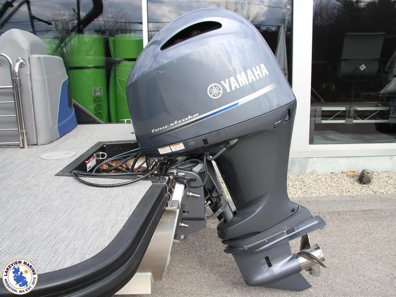 Slide: The Image of 2024 Bennington 23 LXFB with Yamaha outboard motor, displayed outdoors. - 12