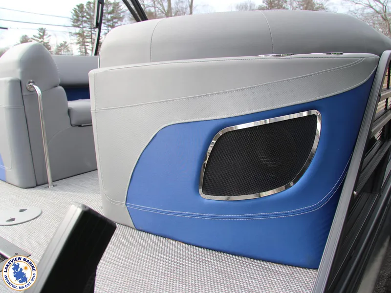 Slide: The Image of 2024 Bennington 23 LXFB boat interior with blue and gray seating and speaker detail. - 13