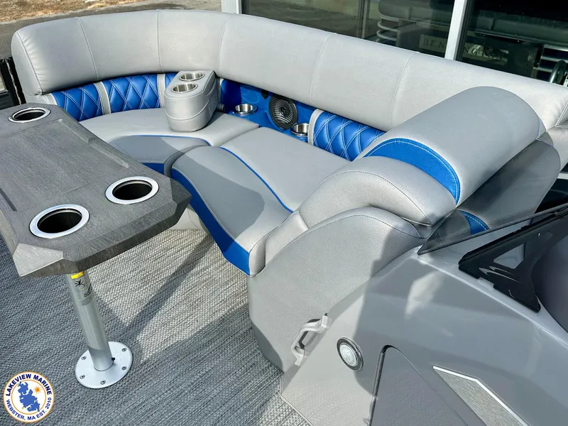 Slide: The Image of 2024 Bennington 23 LXFB boat interior with gray and blue seating and table with cup holders. - 4