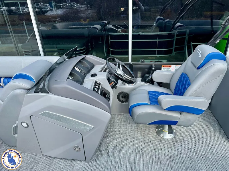 Slide: The Image of 2024 Bennington 23 LXFB boat interior with gray and blue captain's chair and control panel. - 5