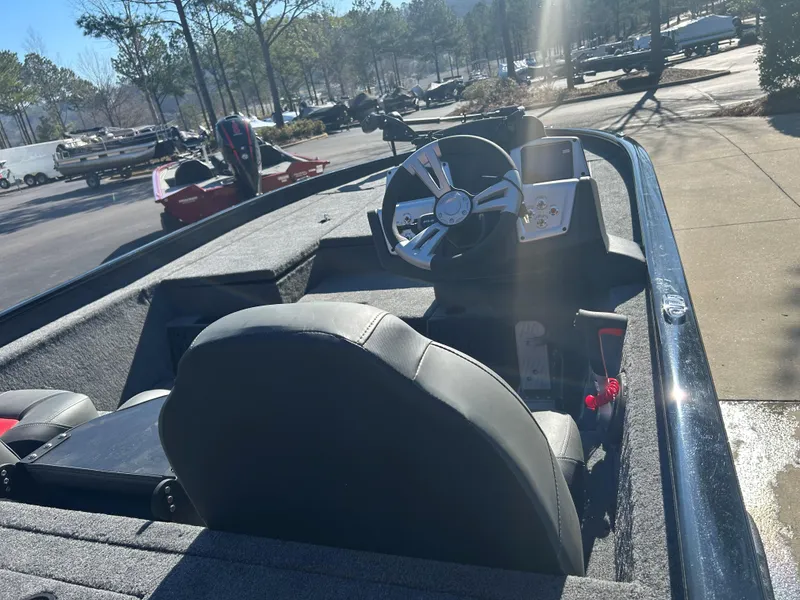 Slide: The Image of 2025 Tracker Savage 215 boat interior with steering wheel and seating in sunlight. - 4