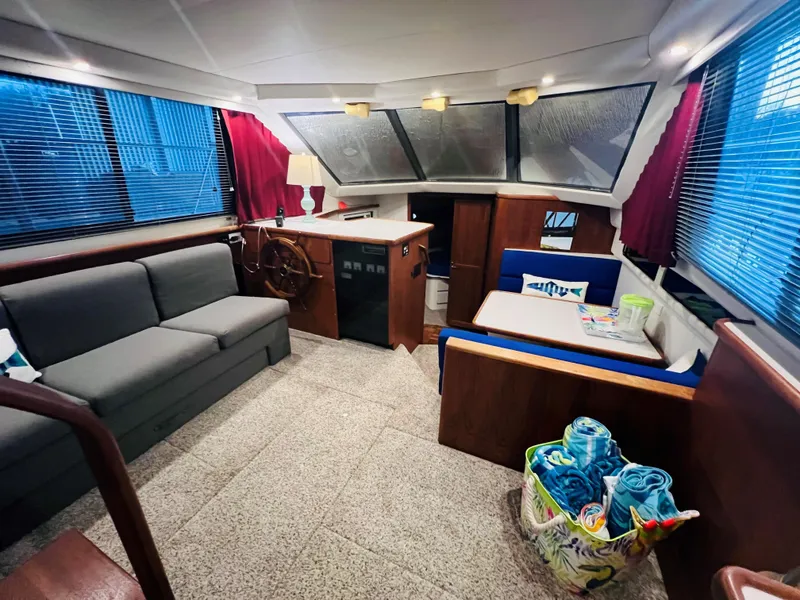 Slide: The Image of Interior of 1994 Carver 350 Aft Cabin with sofa, dining area, and helm station. - 21