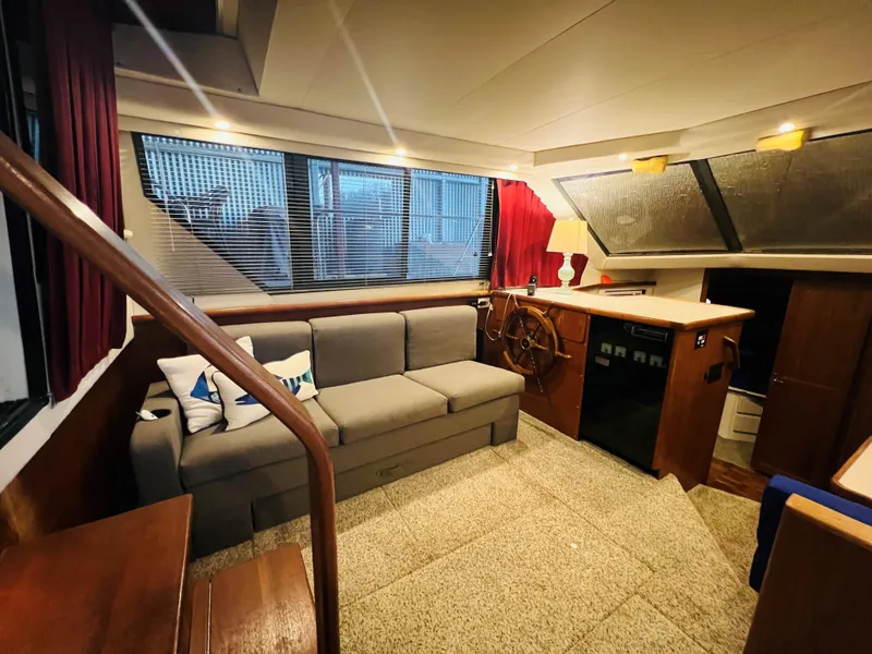 Slide: The Image of Interior of 1994 Carver 350 Aft Cabin with sofa, helm, and windows. - 23