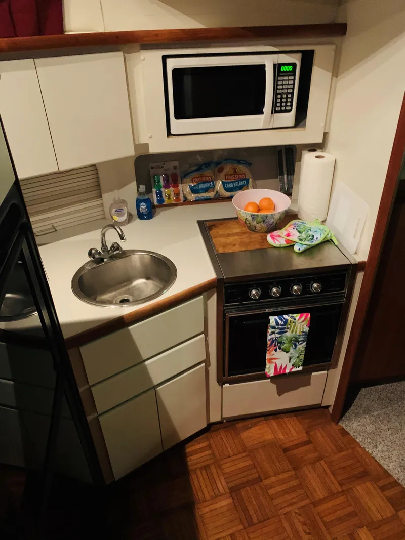 Slide: The Image of Compact kitchen in a 1994 Carver 350 Aft Cabin yacht with microwave and stove. - 28
