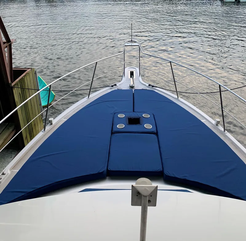 Slide: The Image of 1994 Carver 350 Aft Cabin yacht bow with blue cushions on calm water. - 6