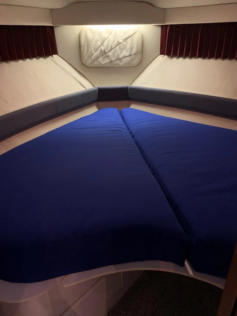 Slide: The Image of 1994 Carver 350 Aft Cabin interior with blue bedding and cozy lighting. - 29