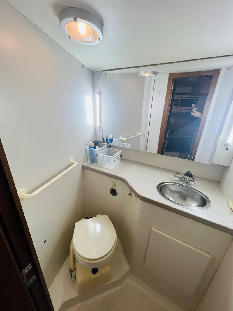 Slide: The Image of 1994 Carver 350 Aft Cabin bathroom with sink, toilet, and mirror. - 30