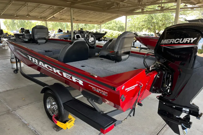 Slide: The Image of 2025 Tracker Pro Team 190 boat with Mercury engine, parked under a shelter. - 2