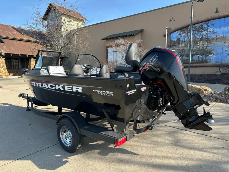 Slide: The Image of 2025 Tracker Pro Guide V-175 Combo boat on trailer, parked outdoors. - 2