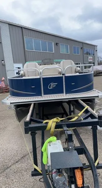 Slide: The Image of 2022 Forester 2208CC pontoon boat on trailer, parked outside industrial building. - 4