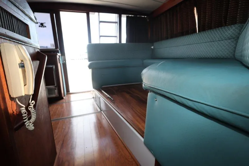 Slide: The Image of Interior of 1988 Bayliner 3888 MY Sedan with teal seating and wood flooring. - 14