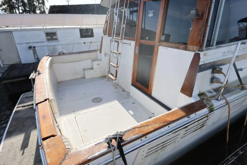 Slide: The Image of 1988 Bayliner 3888 MY Sedan boat deck with wooden trim and ladder. - 2
