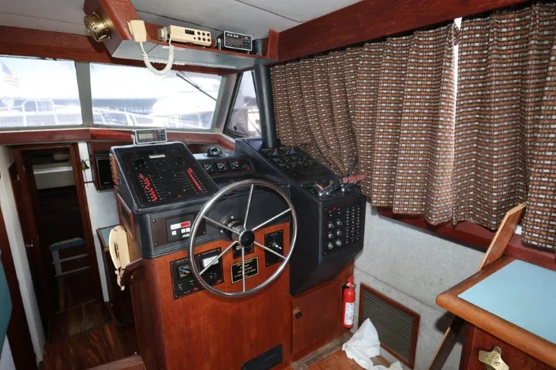 Slide: The Image of 1988 Bayliner 3888 MY Sedan helm with steering wheel, control panels, and nautical instruments. - 4