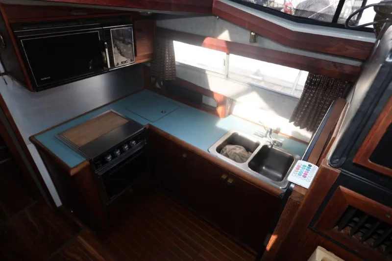 Slide: The Image of 1988 Bayliner 3888 MY Sedan kitchen with stove, sink, and microwave. - 9