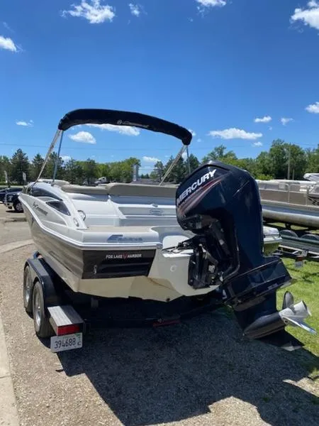 Slide: The Image of 2019 Crownline E 205 XS boat with Mercury outboard motor on trailer, parked outdoors. - 3