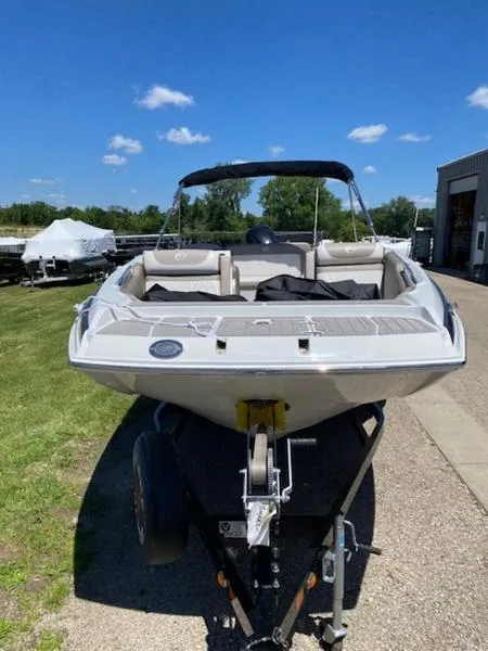 Slide: The Image of 2019 Crownline E 205 XS boat on trailer, parked outdoors under clear sky. - 5