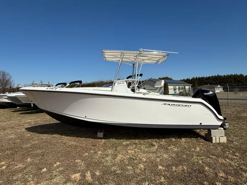 Slide: The Image of 2023 Aquasport 22CC boat on display outdoors, featuring sleek white design. - 1
