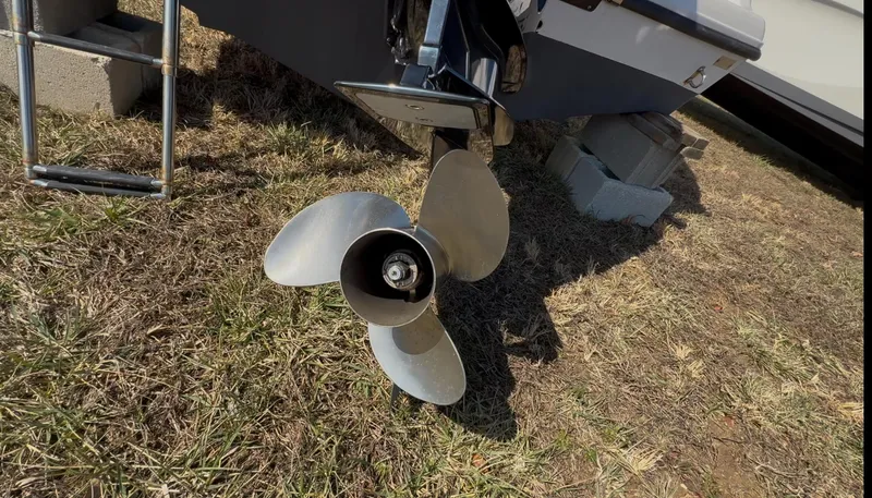 Slide: The Image of 2023 Aquasport 22CC boat propeller on dry grass, showcasing rear view. - 10