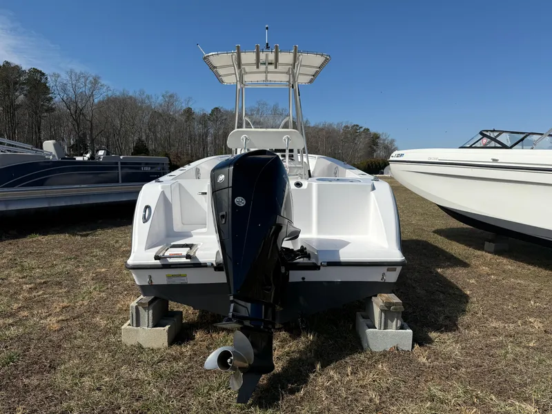 Slide: The Image of 2023 Aquasport 22CC boat with outboard motor, parked on grass. - 4