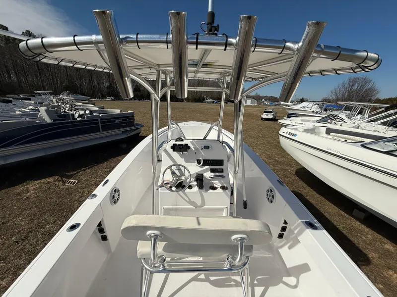 Slide: The Image of 2023 Aquasport 22CC boat with T-top, parked among other boats. - 5