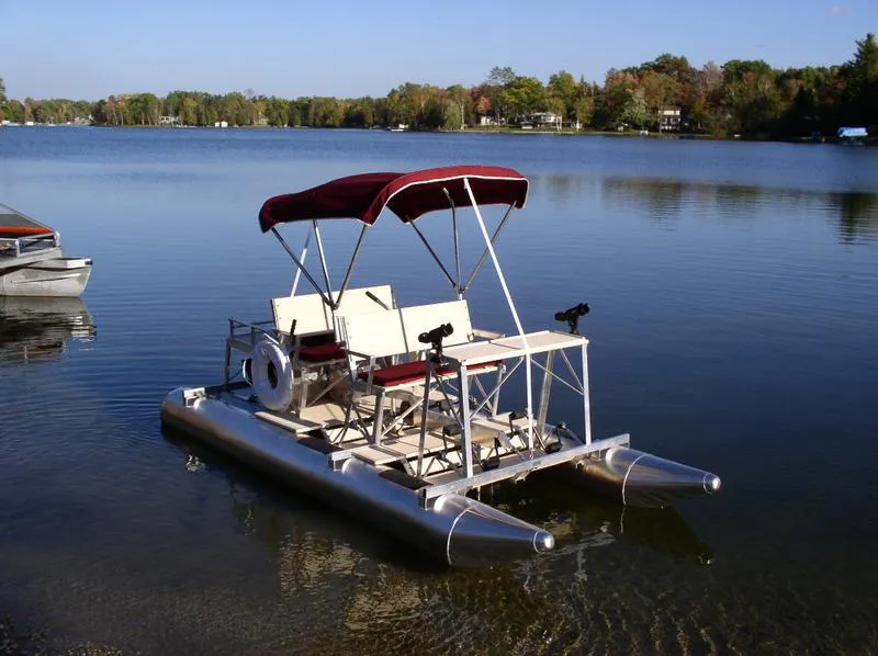 Slide: The Image of 2024 Aqua Cycle AC4x4W pedal boat on a serene lake with a canopy. - 7