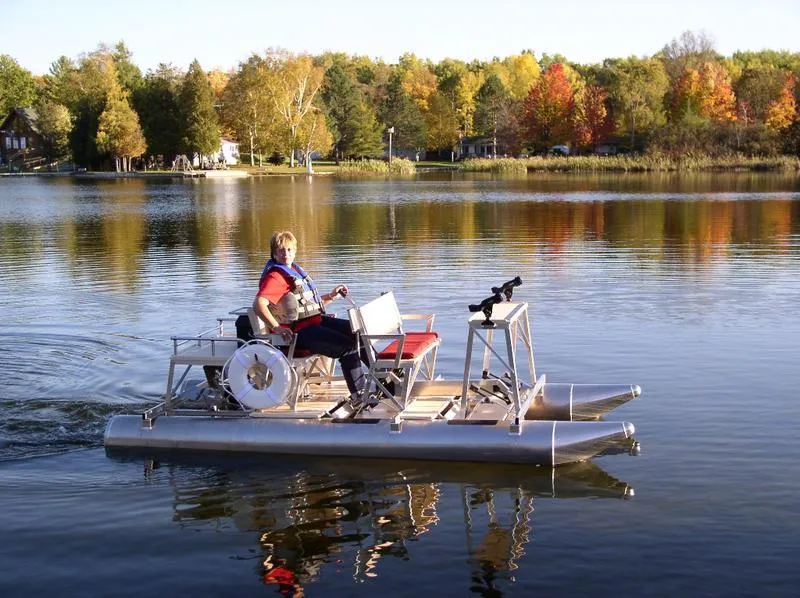 Slide: The Image of Person riding 2024 Aqua Cycle AC4x4W pedal boat on a serene lake. - 9