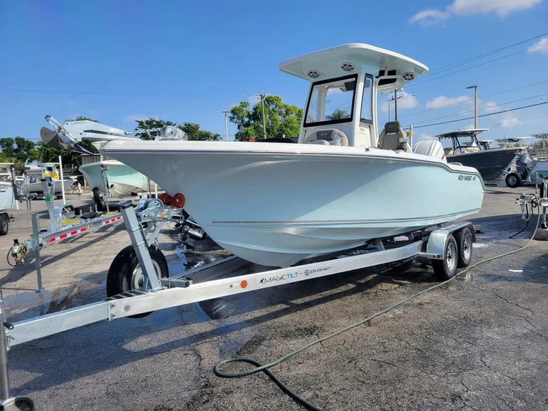 Slide: The Image of 2025 Key West 239 FSR boat on trailer, parked outdoors under clear sky. - 1