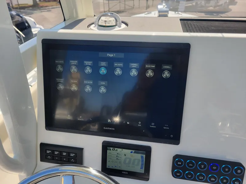 Slide: The Image of 2025 Key West 239 FSR boat dashboard with Garmin display and control panel. - 13