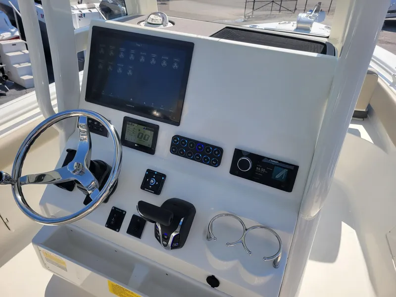 Slide: The Image of 2025 Key West 239 FSR boat dashboard with steering wheel and electronic controls. - 15