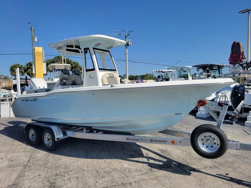 Slide: The Image of 2025 Key West 239 FSR boat on trailer, displayed outdoors under clear blue sky. - 6