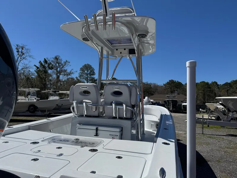 Slide: The Image of 2025 Contender 26 Bay boat with T-top and dual seats, parked outdoors. - 11