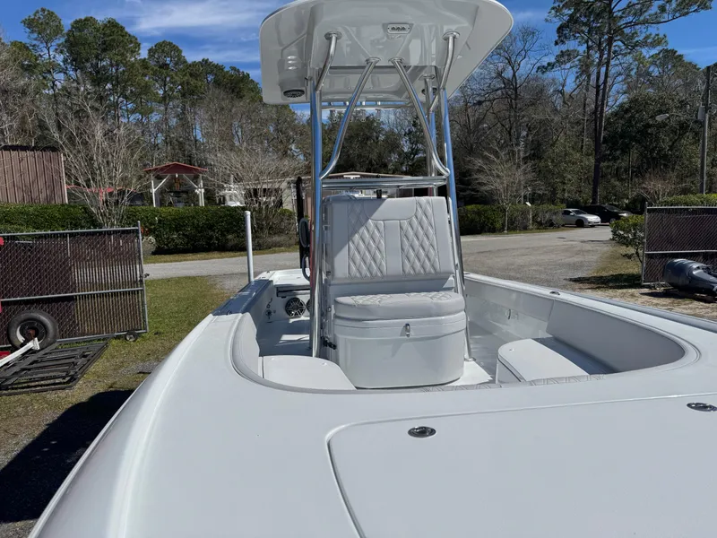 Slide: The Image of 2025 Contender 26 Bay boat with T-top and seating, parked outdoors. - 13