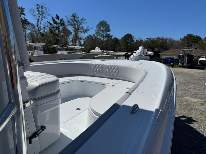 Slide: The Image of 2025 Contender 26 Bay boat with sleek design and spacious seating, parked outdoors. - 19