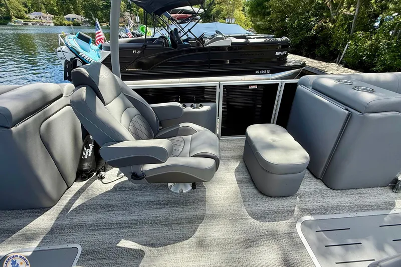 Slide: The Image of 2025 Bennington 26 LSRTD boat interior with gray seating and lake view. - 11
