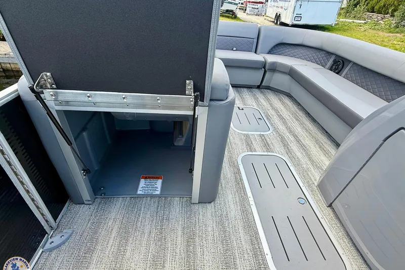 Slide: The Image of 2025 Bennington 26 LSRTD pontoon boat interior with open storage compartment and seating. - 12