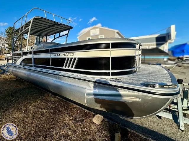 Slide: The Image of 2025 Bennington 26 LSRTD pontoon boat on trailer, sunny day, outdoor setting. - 19
