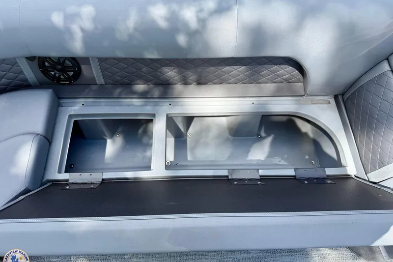 Slide: The Image of 2025 Bennington 26 LSRTD boat storage compartment with quilted upholstery and speaker. - 7