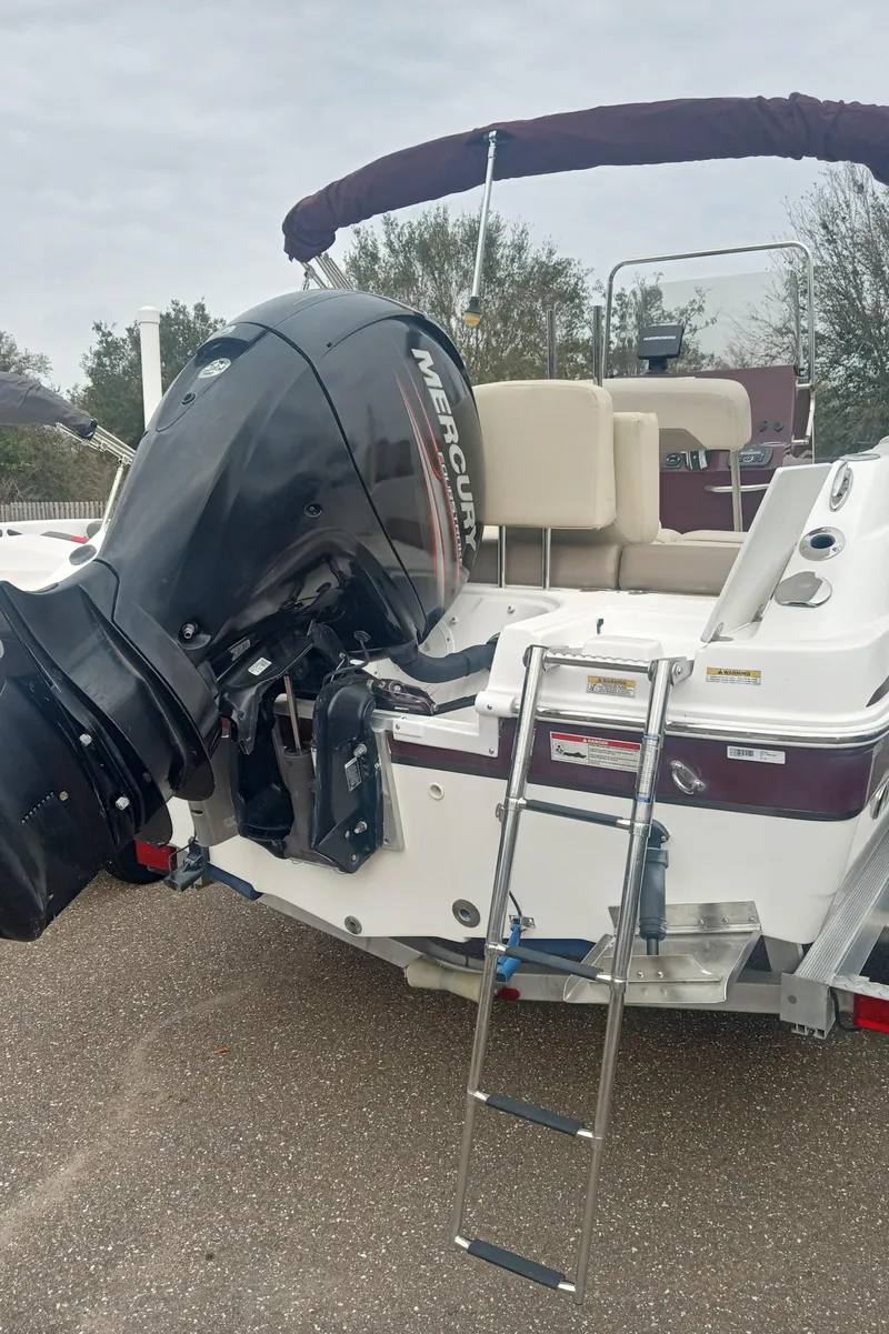 Slide: The Image of 2017 Hurricane CC19 boat with Mercury outboard motor and ladder, parked on pavement. - 4