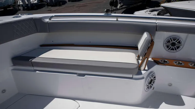 Slide: The Image of 2025 Everglades 455 CC boat seating area with cushioned bench and built-in speakers. - 11
