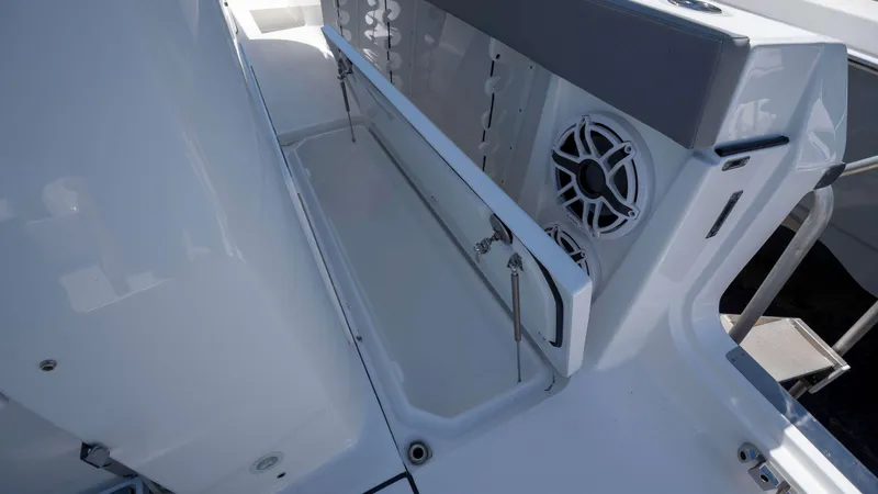 Slide: The Image of 2025 Everglades 455 CC boat interior with storage compartment and speaker. - 21