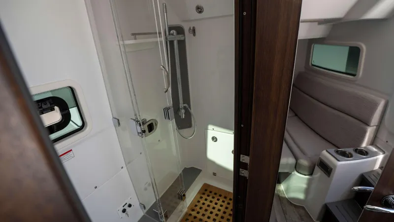 Slide: The Image of Interior of 2025 Everglades 455 CC boat featuring a modern bathroom and seating area. - 27