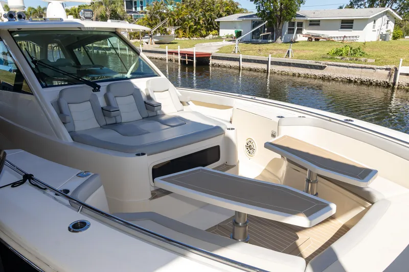 Slide: The Image of 2020 Scout 530LXF luxury boat interior with seating and tables, docked by a canal. - 28