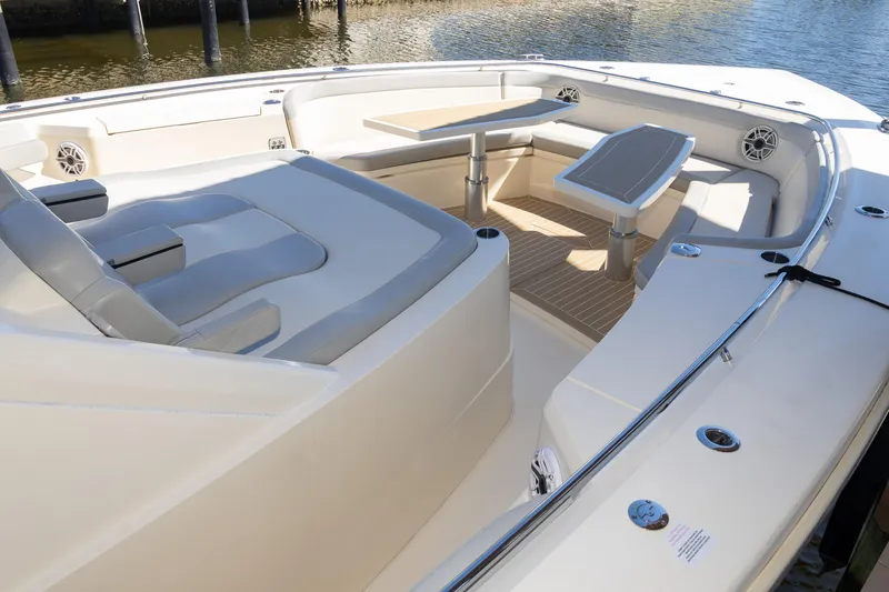 Slide: The Image of 2020 Scout 530LXF boat interior with seating and table, docked by the water. - 31