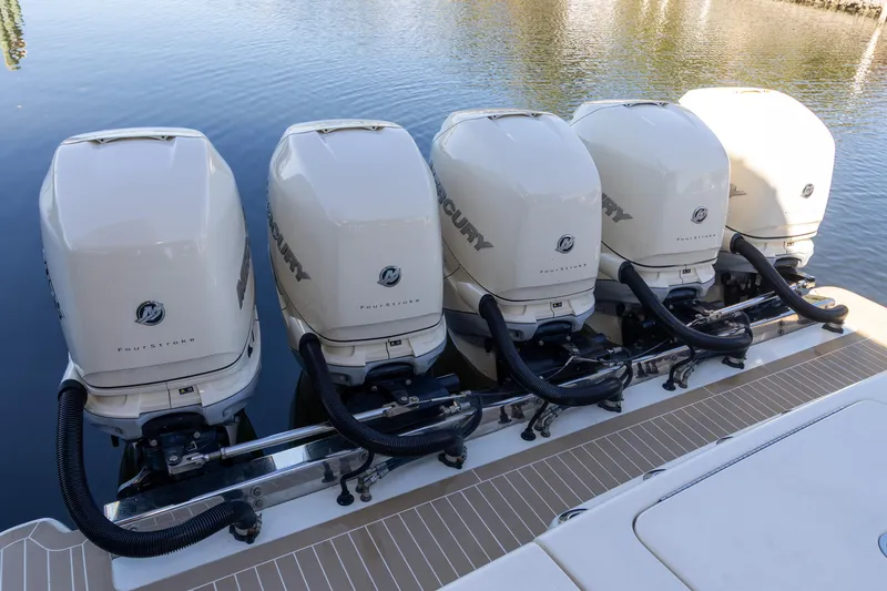 Slide: The Image of Five powerful outboard engines on a 2020 Scout 530LXF boat, docked on calm water. - 4